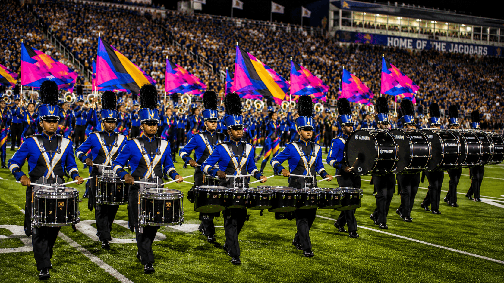 Marching band drumline performing on a football field